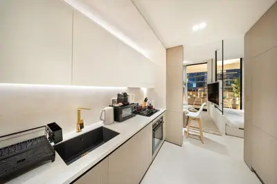 a kitchen with white cabinets and a counter top with a microwave at FIRST CLASS Studio Stylish Near Circle Mall in Dubai