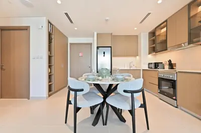 a kitchen with a table and chairs in a room at Luxury 1BR Beach Access Creek Beach in Dubai