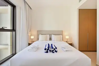 a bedroom with a white bed with towels on it at Luxury 1BR Beach Access Creek Beach in Dubai
