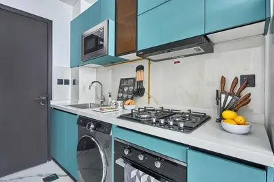 a kitchen with a stove and a washing machine at Frank Porter - Opalz by Danube in Dubai