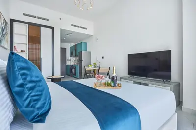a bedroom with a large bed with a blue pillow at Frank Porter - Opalz by Danube in Dubai