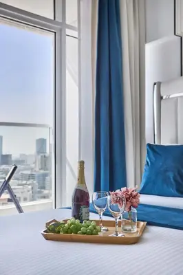a tray of grapes and wine glasses on a bed at Frank Porter - Opalz by Danube in Dubai