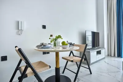 a dining room with a table with chairs and a tv at Frank Porter - Opalz by Danube in Dubai