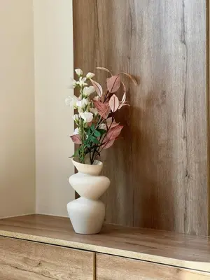 a white vase with flowers in it on a table at Brand New 1BDR with Large Terrace 4 Guests in Dubai
