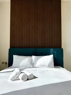 a bed with two rolled towels on top of it at Brand New 1BDR with Large Terrace 4 Guests in Dubai