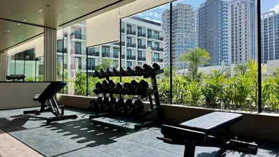 a gym with cardio equipment in front of a large window at Brand New 1BDR with Large Terrace 4 Guests in Dubai
