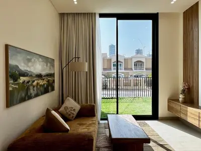 a living room with a couch and a large window at Brand New 1BDR with Large Terrace 4 Guests in Dubai