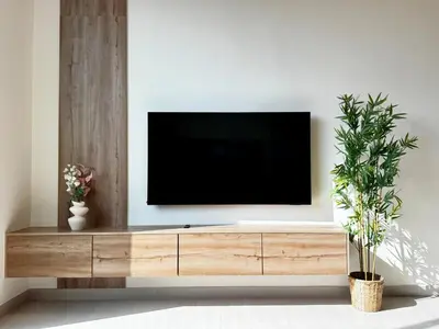 a television sitting on top of a wooden entertainment center at Brand New 1BDR with Large Terrace 4 Guests in Dubai