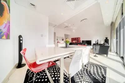 a dining room with a white table and red chairs at Silverene Tower A, Dubai Marina - Mint Stay in Dubai