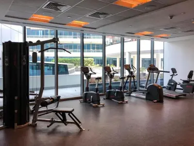 a gym with treadmills and ellipticals in a room with windows at Silverene Tower A, Dubai Marina - Mint Stay in Dubai