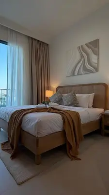 a bedroom with a large bed with a blanket on it at Serene 1BDR in Dubai Hills with Balcony in Dubai