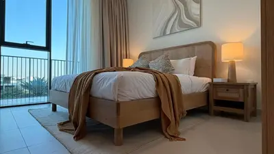a bedroom with a bed with a blanket on it at Serene 1BDR in Dubai Hills with Balcony in Dubai