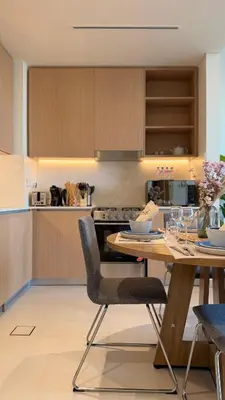 a kitchen with a wooden table and chairs at Serene 1BDR in Dubai Hills with Balcony in Dubai
