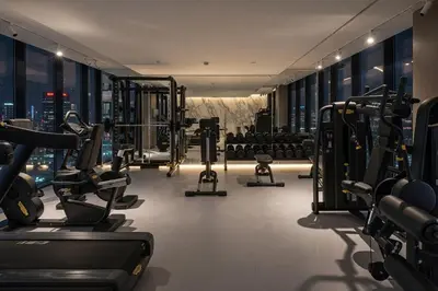 a gym with cardio equipment and a city skyline at Stylish 1BR with Pool & Gym Access in Dubai