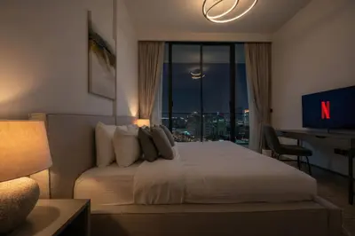 a bedroom with a bed with a view of a city at Stylish 1BR with Pool & Gym Access in Dubai