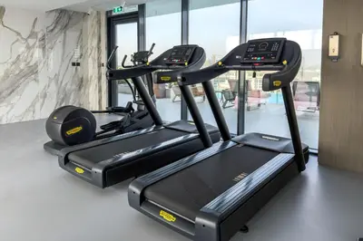 a row of cardio machines in a gym at Stylish 1BR with Pool & Gym Access in Dubai