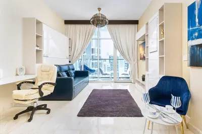 a living room with a blue couch and chairs at Burj Khalifa view cozy studio in Dubai
