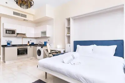 a bedroom with a large bed and a kitchen at Burj Khalifa view cozy studio in Dubai