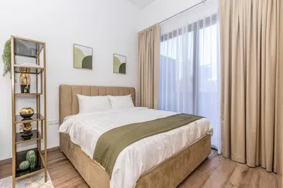 a bedroom with a bed and a large window at Modern & Cozy JVC Studio Couple or Solo in Dubai