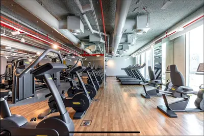 a gym with rows of treadmills and cardio machines at High Rise Building in Burj Vista with Burj Khalifa View in Dubai