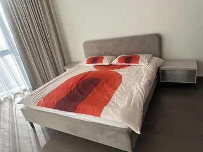 a bed with two pillows and a red blanket at have fun with your family and friends in our apt in Dubai