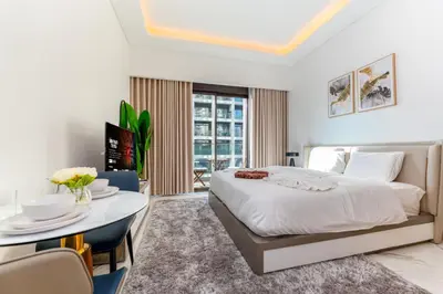 a bedroom with a bed and a table and chairs at Stylish City Studio with Balcony View in Meydan in Dubai