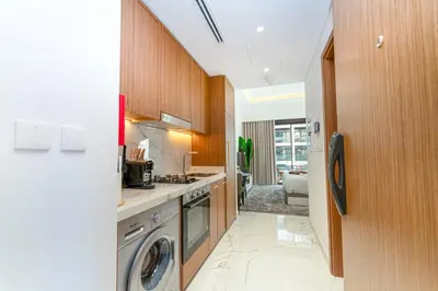 a kitchen with a washer and dryer in it at Stylish City Studio with Balcony View in Meydan in Dubai