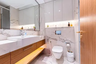 a white bathroom with a sink and a toilet at Stylish City Studio with Balcony View in Meydan in Dubai