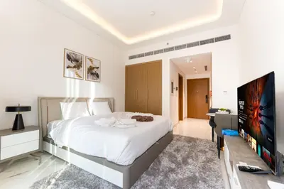 a bedroom with a bed and a flat screen tv at Stylish City Studio with Balcony View in Meydan in Dubai