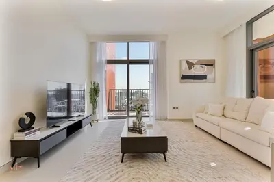a living room with a white couch and a tv at Executive 1BR at Hadley Heights, JVC Dubai with balcony City Views in Dubai