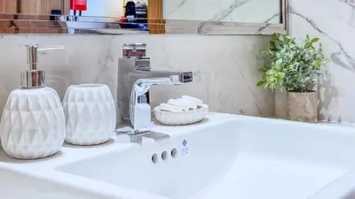 a white bathroom sink with a faucet and a mirror at TRPS - Azizi RIviera 63, Al Meydan - Brand New Studio, Modern Furnished, Excellent Amenities in Dubai