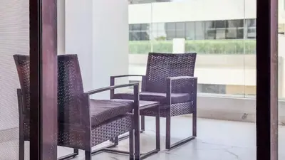 two chairs sitting in front of a window at TRPS - Azizi RIviera 63, Al Meydan - Brand New Studio, Modern Furnished, Excellent Amenities in Dubai