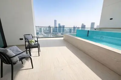 a room with a swimming pool and chairs in a building at Luxury 2BR W Private Pool Binghattti Onyx in Dubai