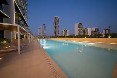 a swimming pool with a city skyline in the background at Luxury 2BR W Private Pool Binghattti Onyx in Dubai