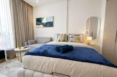 a bedroom with a large bed with a blue blanket at Premium Studio W Pool & Gym Binghatti Aurora in Dubai