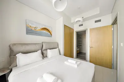 a bedroom with a large white bed with white pillows at Daniels 2BR with Canal View at Aykon City in Dubai