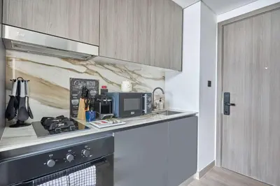 a kitchen with a stove and a counter top at Frank Porter - Oxford Gardens in Dubai
