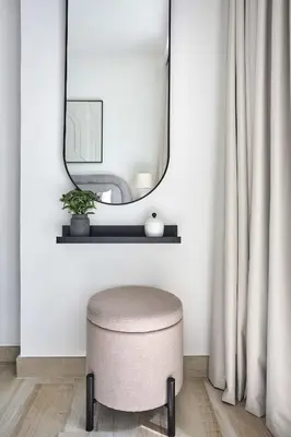 a round stool in a room with a mirror at Frank Porter - Oxford Gardens in Dubai
