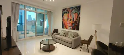 a living room with a couch and a glass table at Silk Valley - Luxury 1BR: Steps to Barasti Beach & Marina Walk in Dubai
