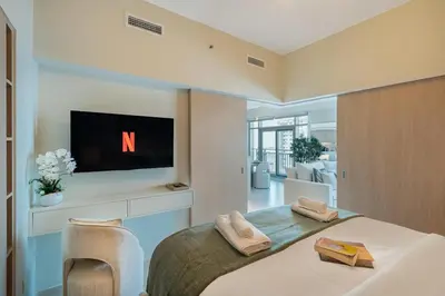 a bedroom with a large bed with a tv on the wall at Stylish 1BDR Fully Upgraded Near Burj Khalifa in Dubai