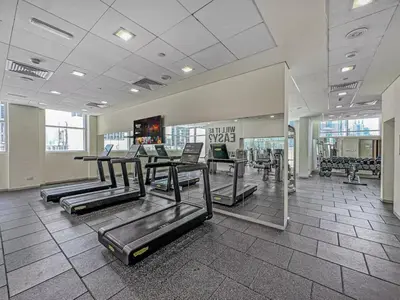 a gym with rows of exercise equipment in a building at Stylish 1BDR Fully Upgraded Near Burj Khalifa in Dubai