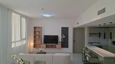 a living room with white furniture and a television at Equity Gate 217 in Dubai