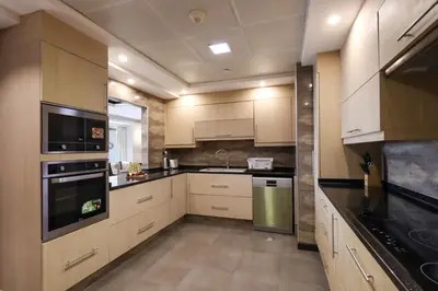 a kitchen with white cabinets and black counter tops at Prime JBR 4B with Maid with Sea and Ain Dubai View in Dubai