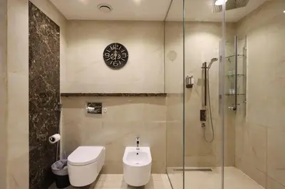 a bathroom with a toilet and a glass shower at Prime JBR 4B with Maid with Sea and Ain Dubai View in Dubai