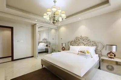 a bedroom with a large white bed and a chandelier at Prime JBR 4B with Maid with Sea and Ain Dubai View in Dubai