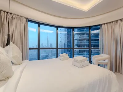 a bedroom with a white bed and a large window at Hollywood Glamour Epic Burj Views at DAMAC Towers by Paramount in Dubai