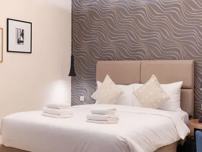a bed with white sheets and pillows in a bedroom at Hollywood Glamour Epic Burj Views at DAMAC Towers by Paramount in Dubai