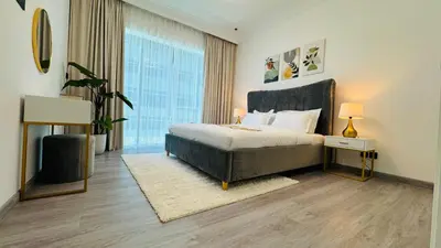 a bedroom with a bed and a large window at 1 Bedroom with Balcony - Near Metro - Fast Wi-Fi in Dubai