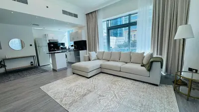 a living room with a couch and a large window at 1 Bedroom with Balcony - Near Metro - Fast Wi-Fi in Dubai