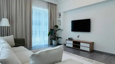 a living room with a couch and a flat screen tv at 1 Bedroom with Balcony - Near Metro - Fast Wi-Fi in Dubai